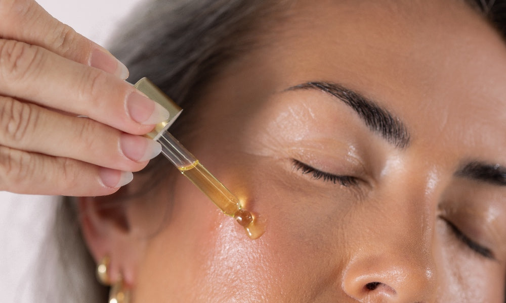 A woman rubbing Dr Tanya Holy Basil Face Serum together in her hands. 